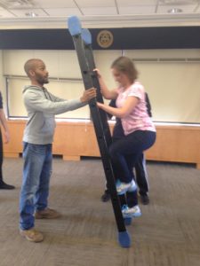 Two Landforce staff members using a ladder to build trust.